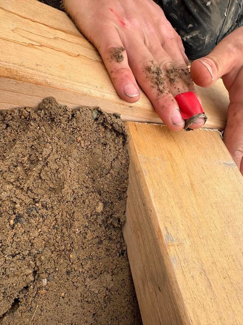 Checking a tight timber corner joint on a raised bed filled with soil