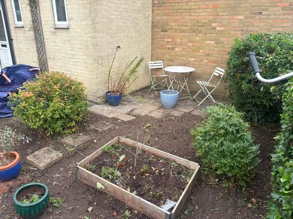 Tidy courtyard garden with seating area and raised bed